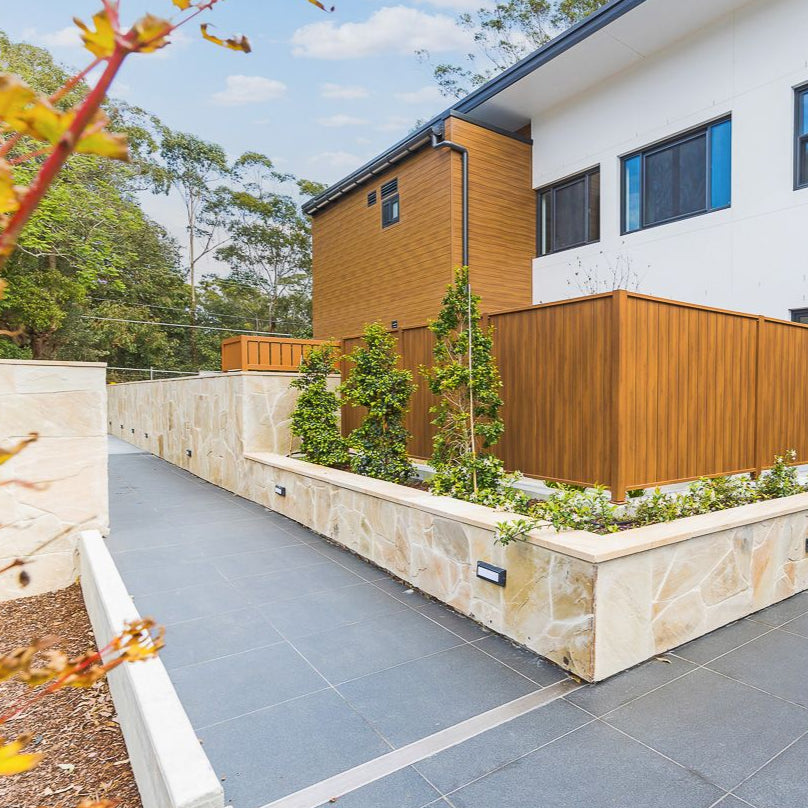 Sunrise Gold gold-toned irregular stone installed on a garden wall by Tilemall