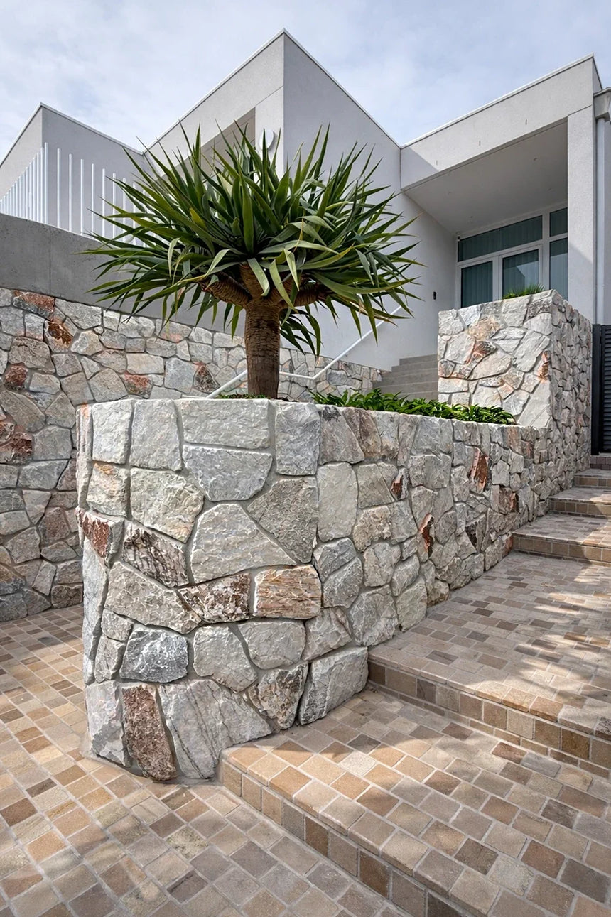 Sienna stone wall cladding beside exterior steps and landscaping — matching walling finish reference for corners by Tilemall
