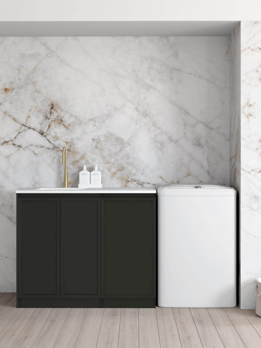 Otti Hampshire 1060mm matte black floor-standing laundry set with Pure White stone top and undermount sink, beside a washing machine