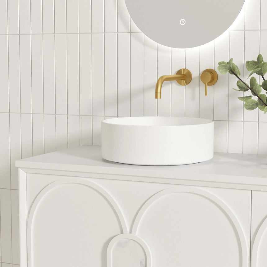 Single white vessel basin on Otti Laguna MK II vanity with brass wall-mount tap and curved door detail by Tilemall