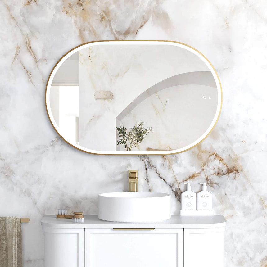 Otti Noosa 900x600mm LED framed mirror by Tilemall with brushed gold metal frame, installed above white vanity