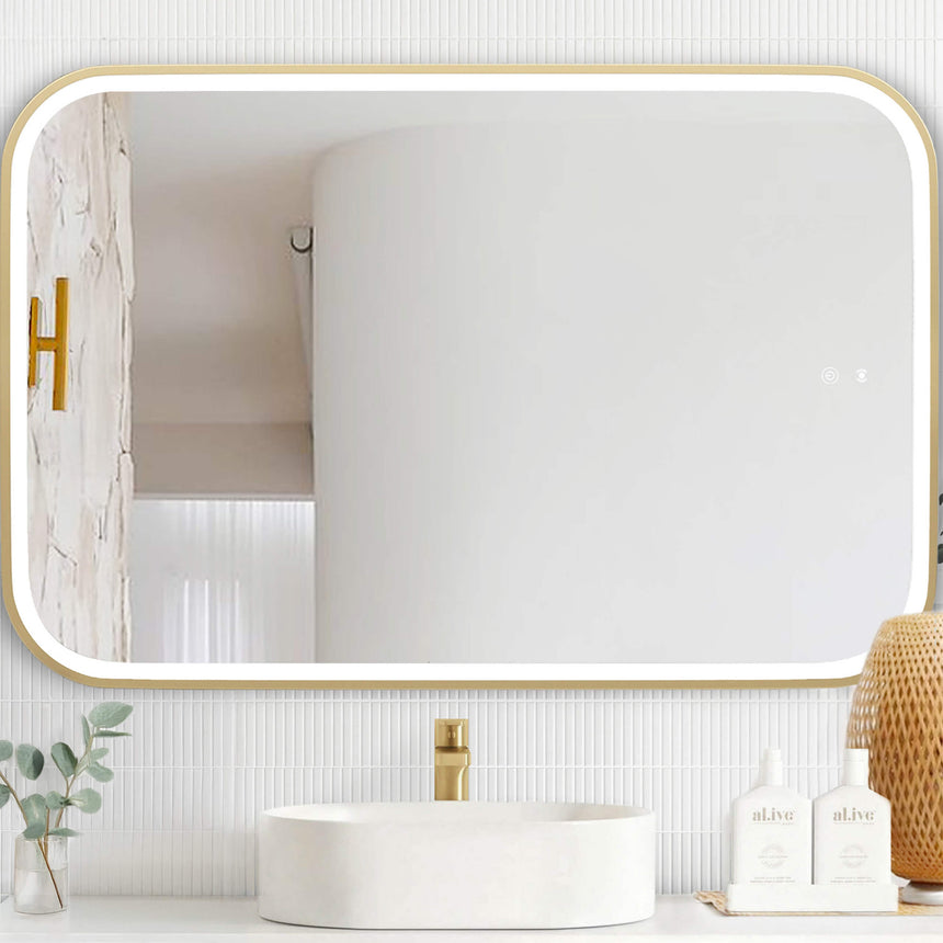 Otti Newport 1200x750mm brushed gold LED mirror installed above white vessel basin in modern bathroom interior by Tilemall