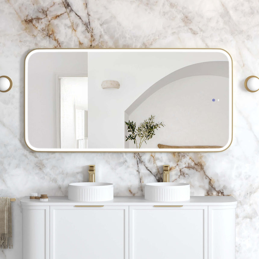 Otti Newport 1500x750mm LED framed mirror by Tilemall with brushed gold metal frame, installed above dual basins in marble ensuite