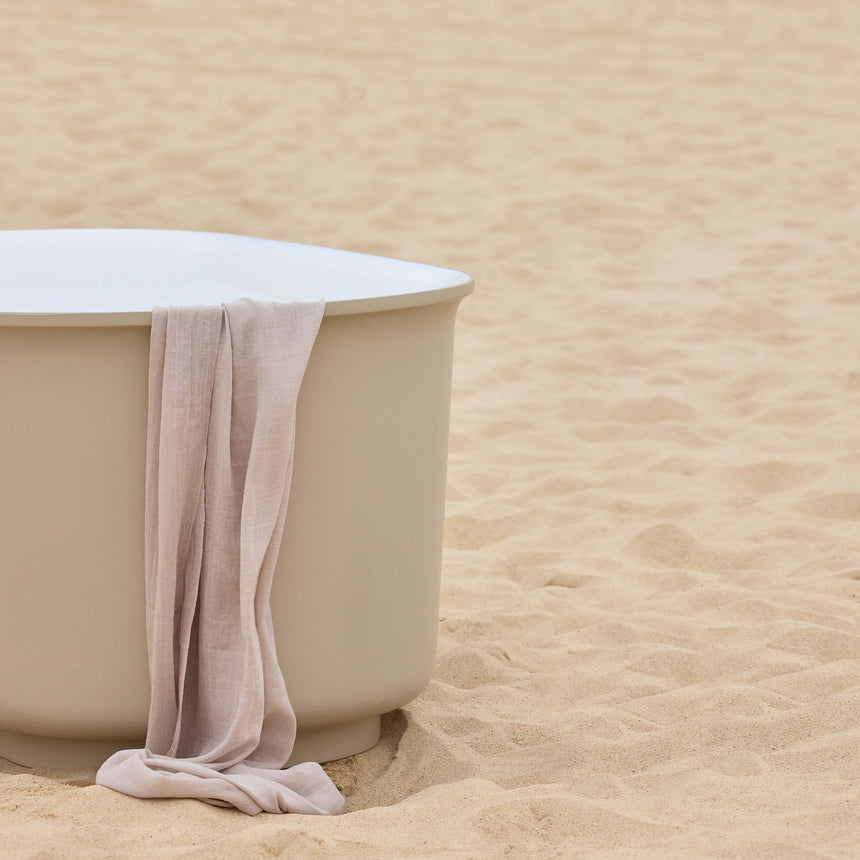 BelBagno Bath berg 1700mm bathtub by Tilemall on sand with linen towel draped over soft sand-coloured rim
