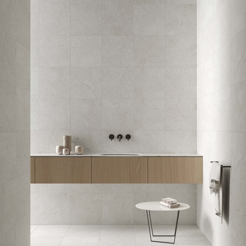 Crema Marfil 300x300mm matt bianco porcelain tiles installed on bathroom wall and floor around sink vanity by Tilemall