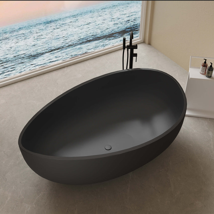 Waverton 1800x1100mm matte black freestanding bathtub installed in bathroom interior, side view showing oval shape and overflow detail by Tilemall