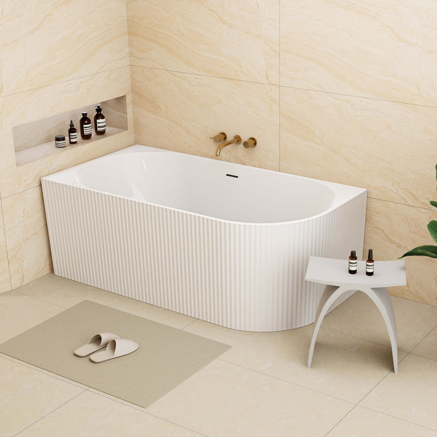 Bingie Lukka Corner Bath 1500x750mm installed in bathroom corner with cream tile walls and brass wall-mounted tap by Tilemall