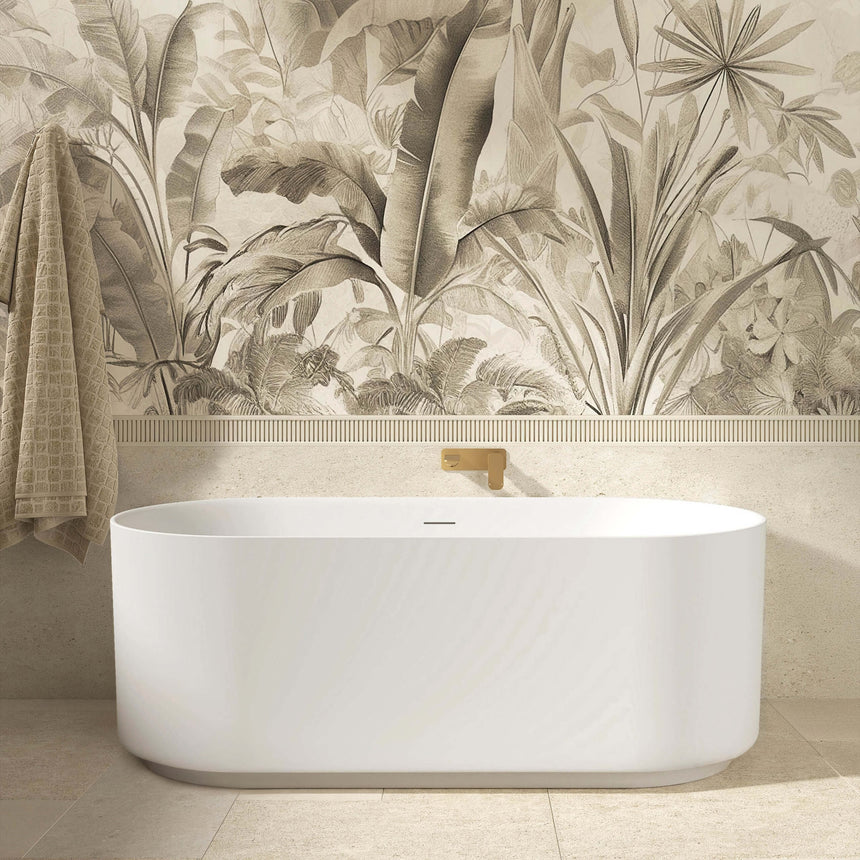 Otti Attica Celine freestanding bathtub positioned against feature wall with botanical wallpaper and brass filler tap by Tilemall