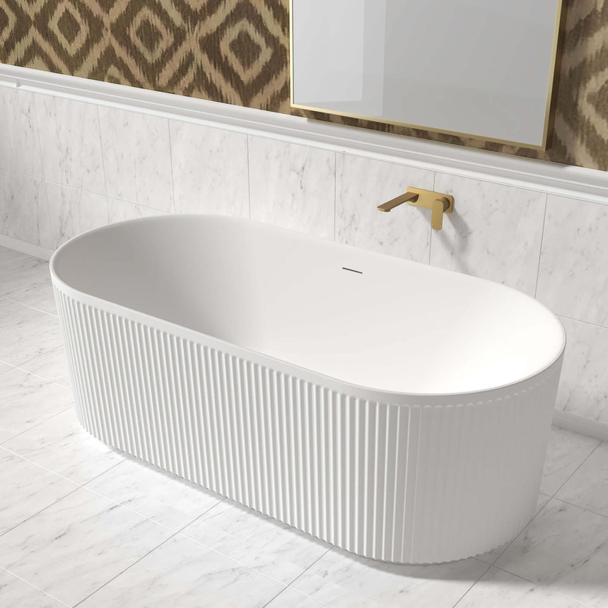 Otti Attica Havana bathtub in modern ensuite with patterned wallpaper and gold-framed mirror above by Tilemall