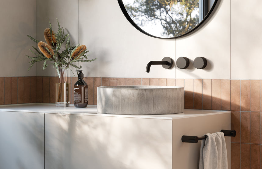 Phoenix Axia matte black wall basin mixer installed on stone countertop above vessel basin with knurled handles by Tilemall