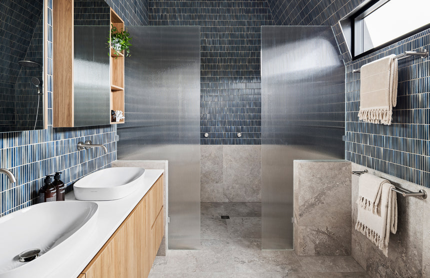 Phoenix Radii brushed nickel towel rail installed in modern bathroom above grey stone tiles by Tilemall