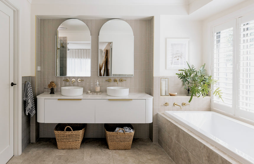 Phoenix Vivid Slimline Plus brushed gold bath spout installed on bathtub edge above white tub by Tilemall