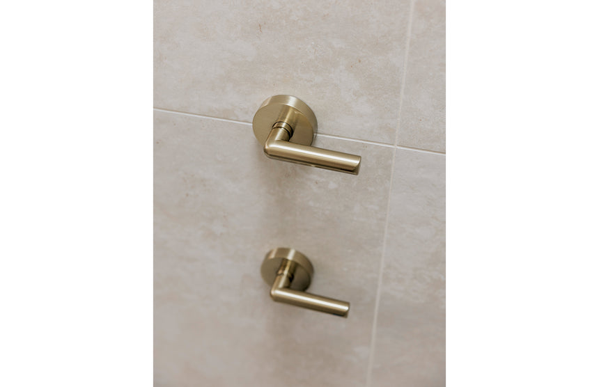 Phoenix Vivid Slimline Plus brushed gold shower system with lever controls installed on grey tile by Tilemall