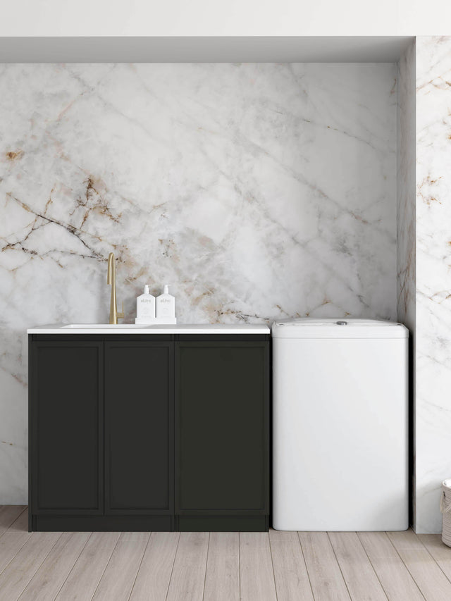 Otti Hampshire 1060mm matte black floor-standing laundry set with Pure White stone top and undermount sink, beside a washing machine