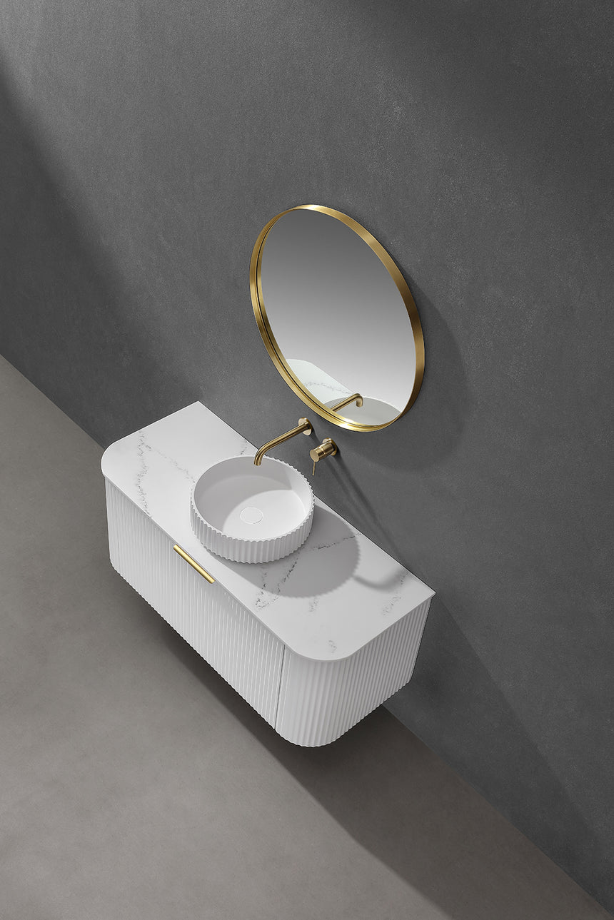 Lukka 400x400mm olley fluted basin installed on white vanity with round brass-framed mirror in bathroom interior by Tilemall