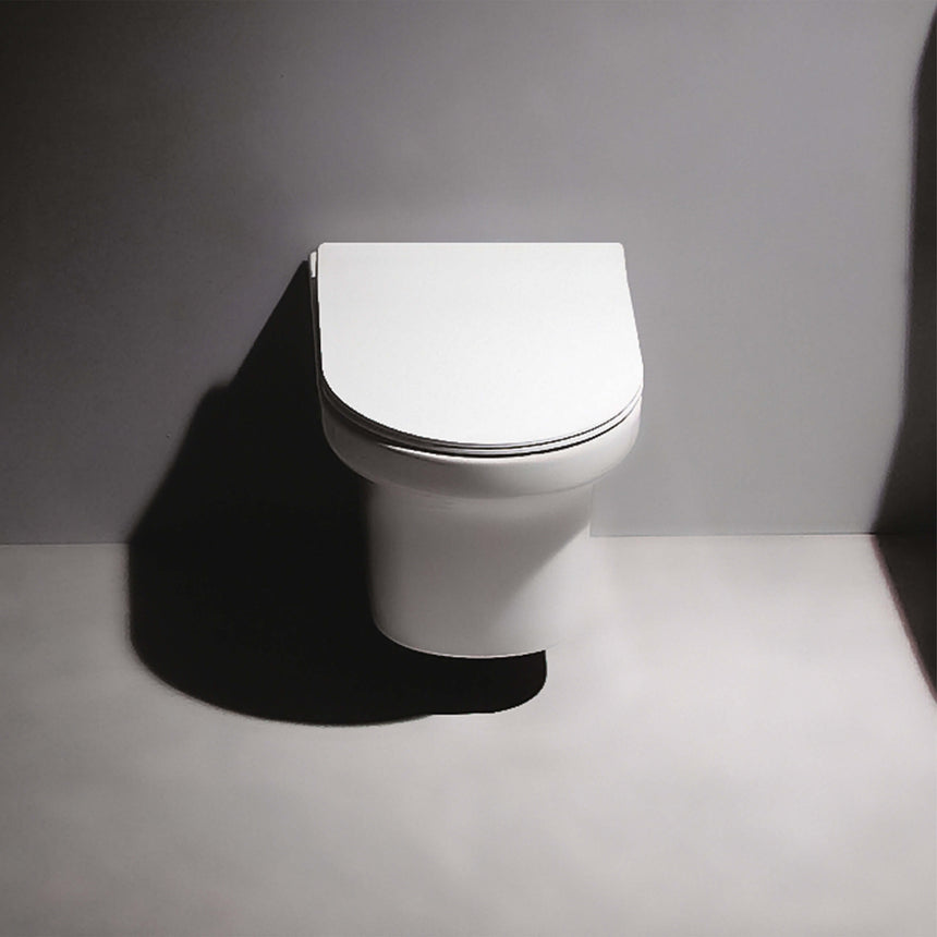 BelBagno Vella-R wall-hung toilet installed in bathroom interior, side view showing ceramic bowl and seat by Tilemall