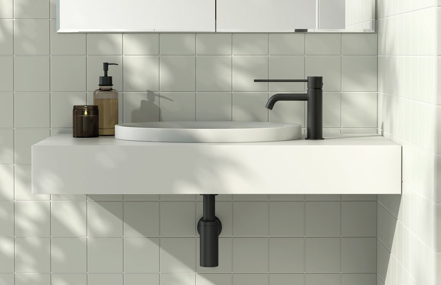 Phoenix Vivid Slimline Basin Mixer Curved Outlet with Extended Lever Brushed Carbon, shown in a finished interior