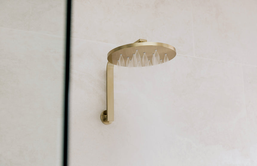 Phoenix LuxeXP Shower Rose 250mm Round Brushed Gold, shown in a finished interior