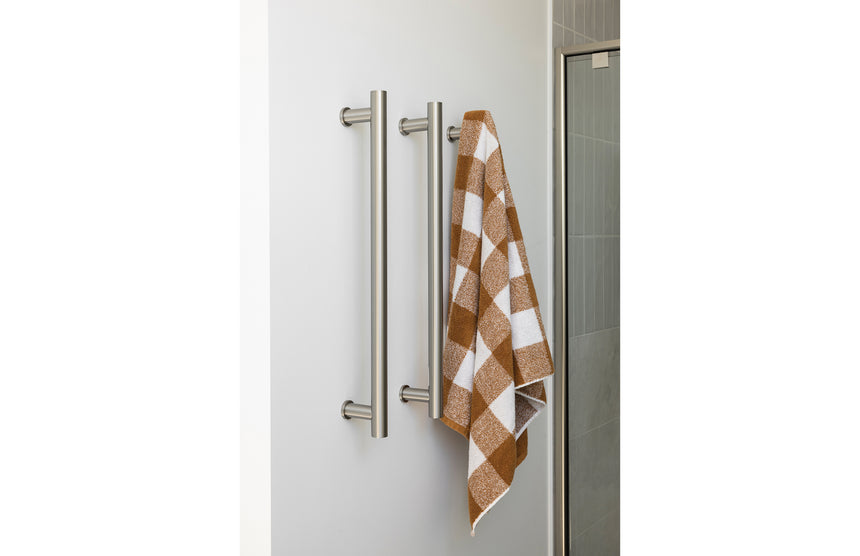 Phoenix Heated Triple Towel Rail Round 600mm Brushed Nickel, shown in a finished interior