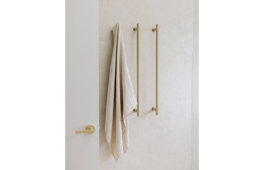 Phoenix Heated Triple Towel Rail Round 800mm Brushed Gold, shown in a finished interior