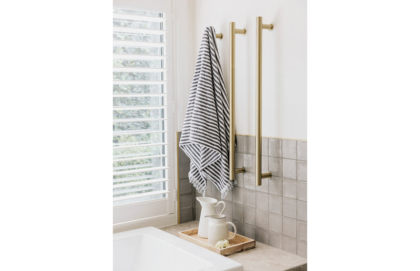 Phoenix Heated Triple Towel Rail Round 800mm Brushed Gold, shown in a finished interior