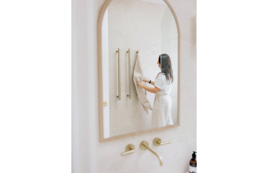 Phoenix Heated Triple Towel Rail Round 800mm Brushed Gold, shown in a finished interior