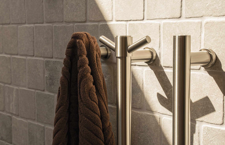 Phoenix Heated Triple Towel Rail Round 600mm Brushed Nickel, shown in a finished interior