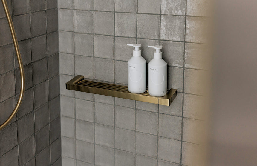 Phoenix Gloss Shower Shelf Brushed Gold, shown in a finished interior